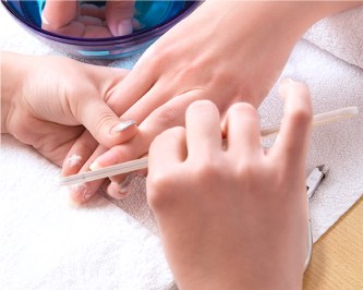 Manicure sendo feita sobre toalha Luxor